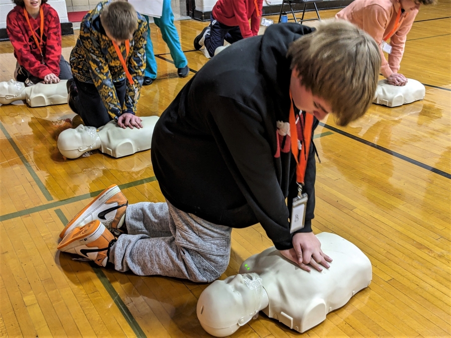 Student performing CPR on a manikin.